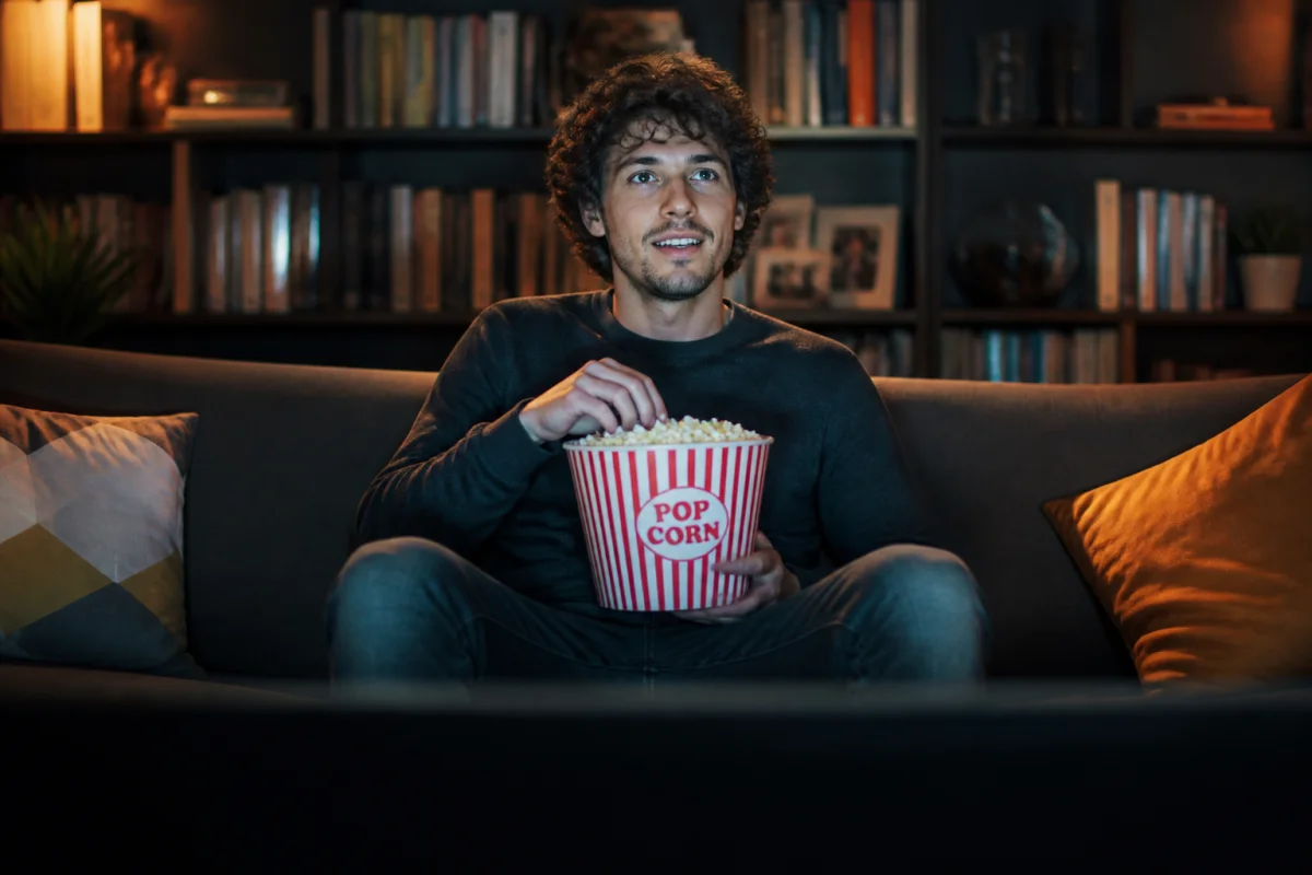 Spectateur passionné confortablement installé dans un salon moderne pour regarder un film en c captivant.